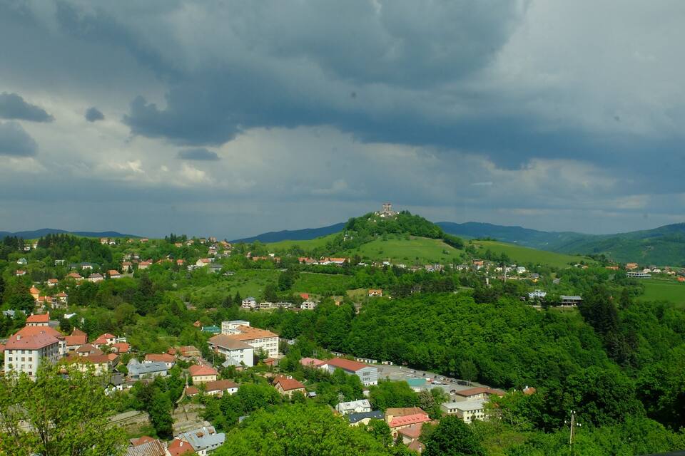 A town nestled in a valley with a prominent hilltop castle.