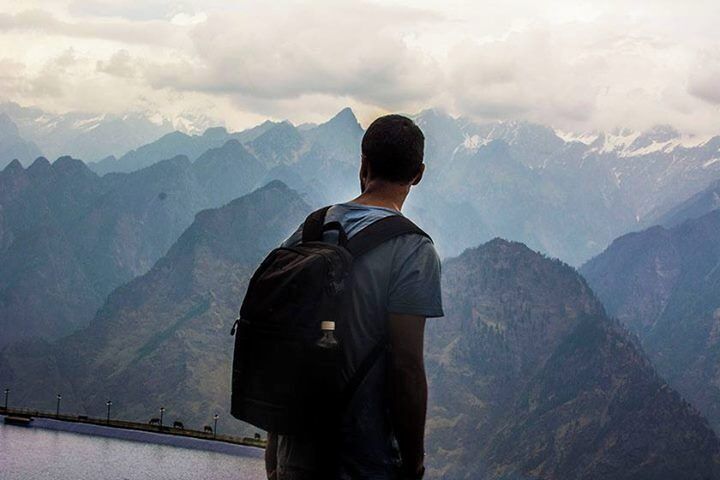 A person with a backpack overlooking a mountain range.