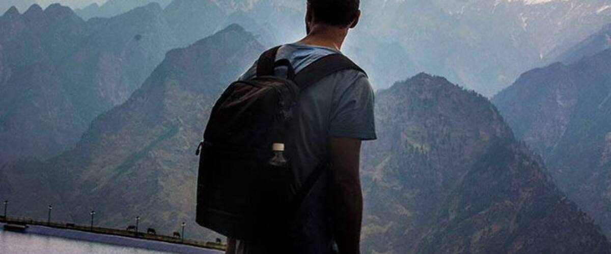 A person with a backpack overlooking a mountain range.