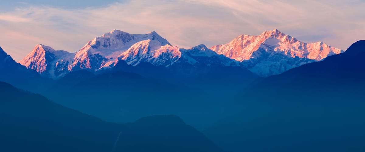 A range of snow-capped mountains with a clear sky.
