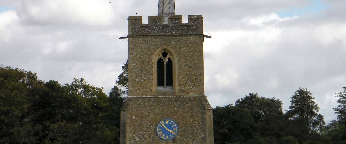 A church with a tall spire and a clock on the tower.