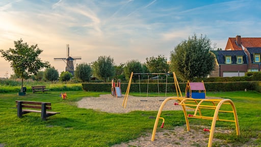 Child-friendly dutch neighborhood with playground and a traditional windmill in the village of Terheijden, North Brabant, The Netherlands