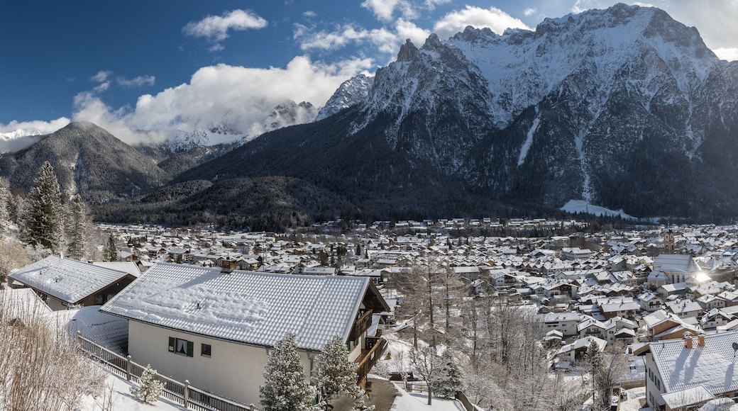 A snow-covered town nestled between mountains, with a prominent church spire visible.