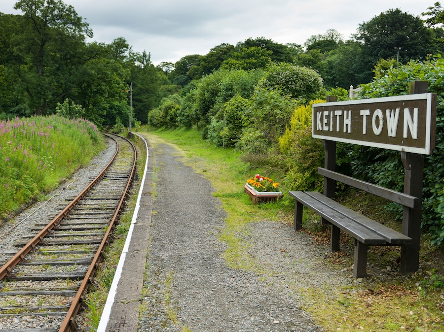 Ett järnvägsspår med en bänk och en skylt med texten ”KEITH TOWN”.