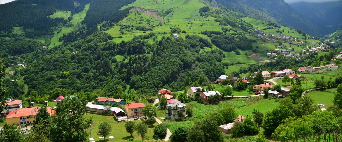 A mountainous landscape with a village nestled in the valley.