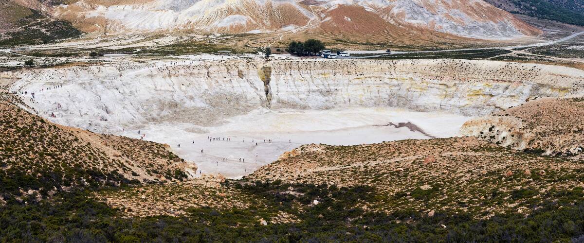 A large open-pit mine with a road leading into the distance.