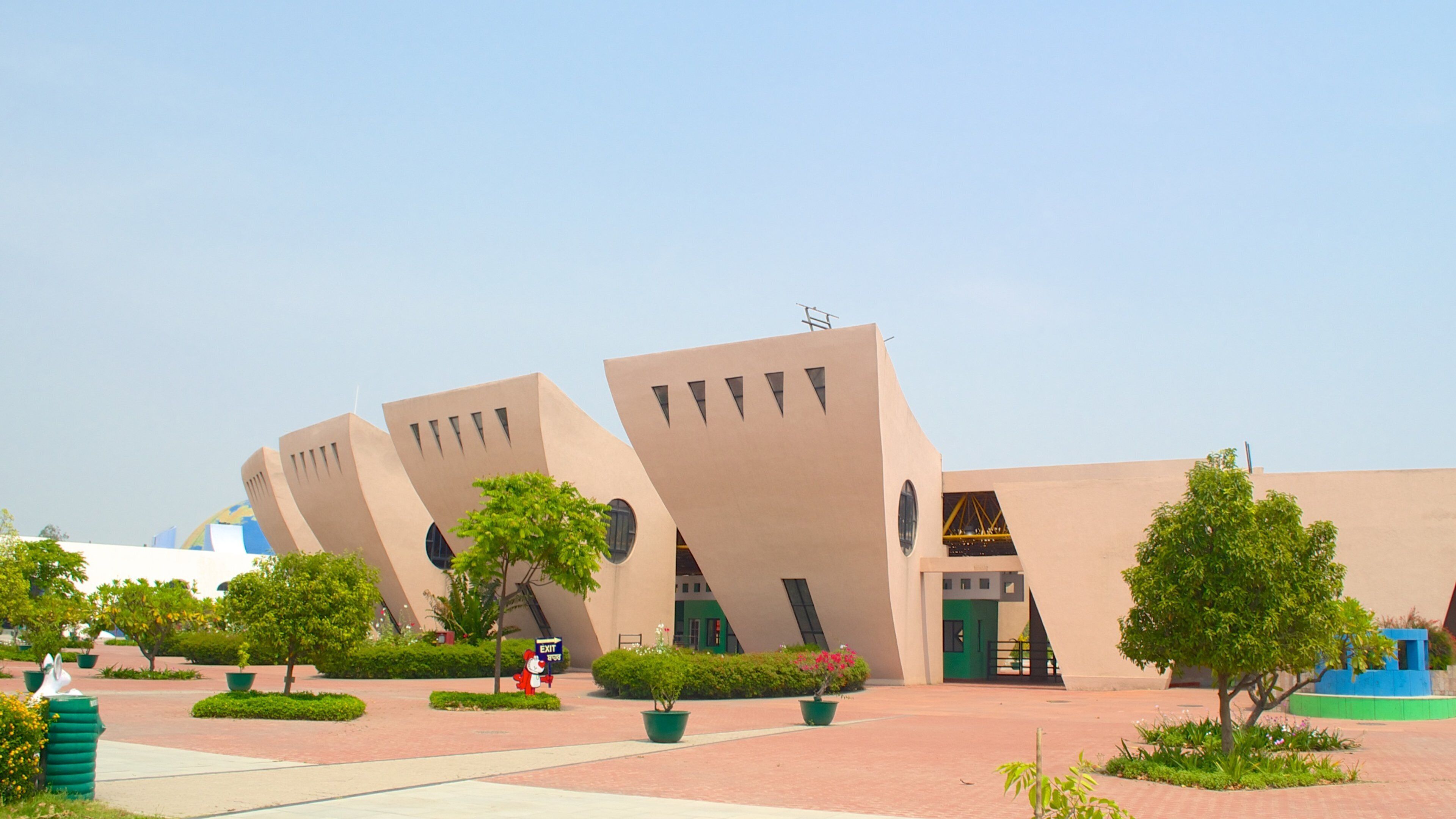A modern building with unique angular architecture and a clear blue sky.