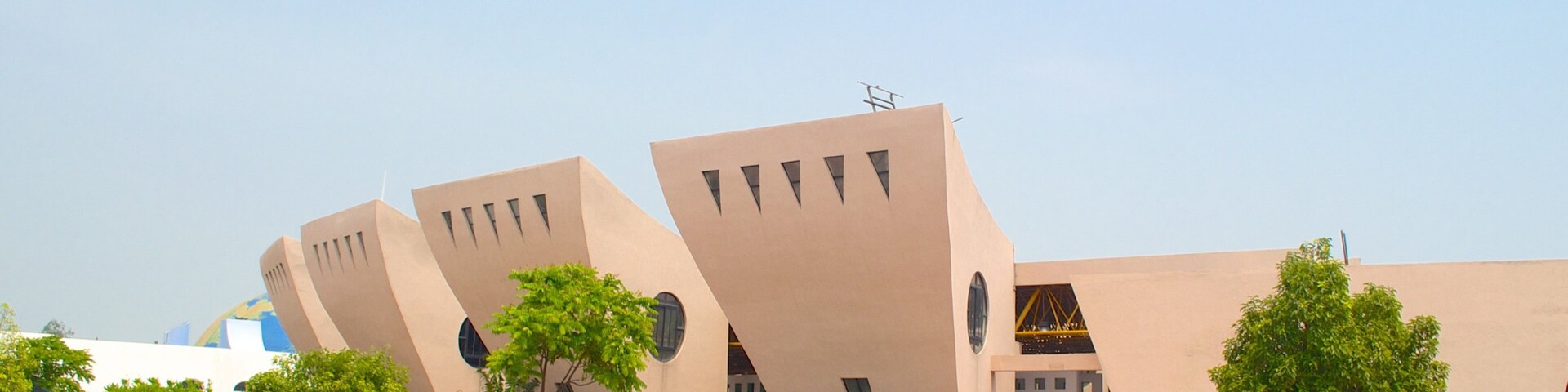 A modern building with unique angular architecture and a clear blue sky.