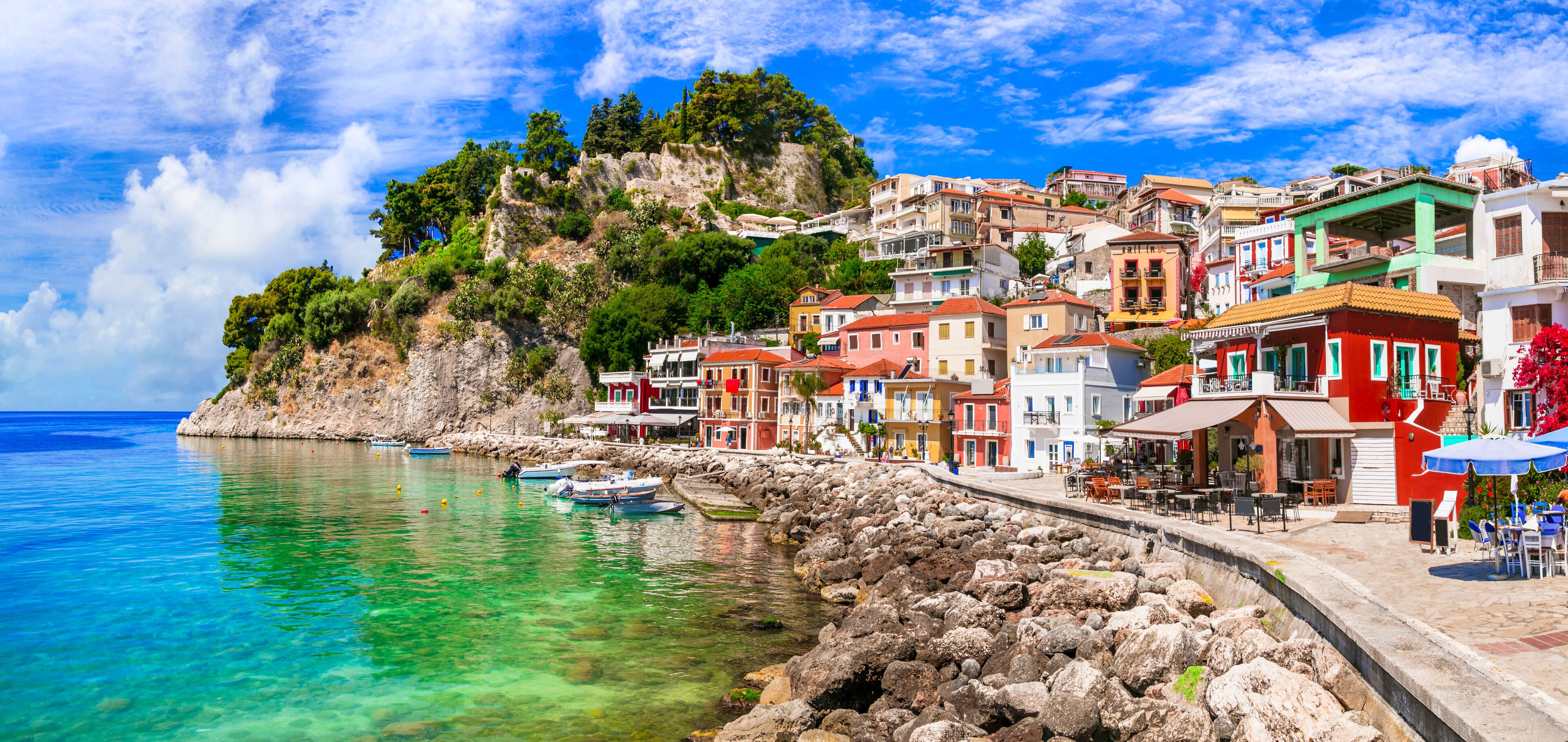 A coastal town with colorful buildings, clear turquoise waters, and rocky cliffs.