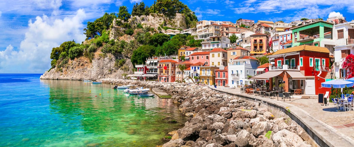 A coastal town with colorful buildings, clear turquoise waters, and rocky cliffs.
