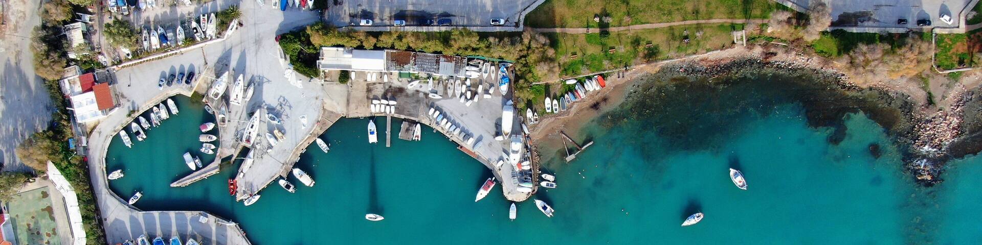 Aerial drone bird's eye view of small marina with boats docked in Voula, Athens riviera, Attica, Greece