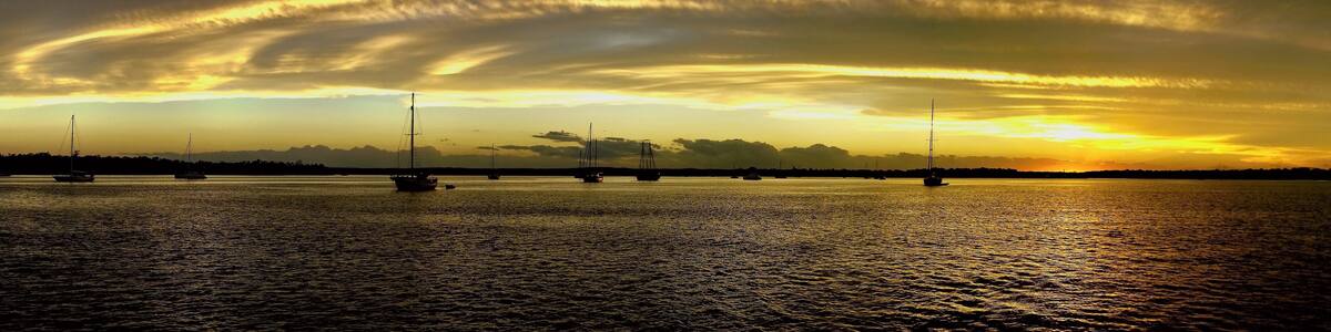 Yellow and gold coloured cirrostratus cloudy coastal nautical Sunset Seascape panorama. Tin Can Bay, Queensland, Australia.