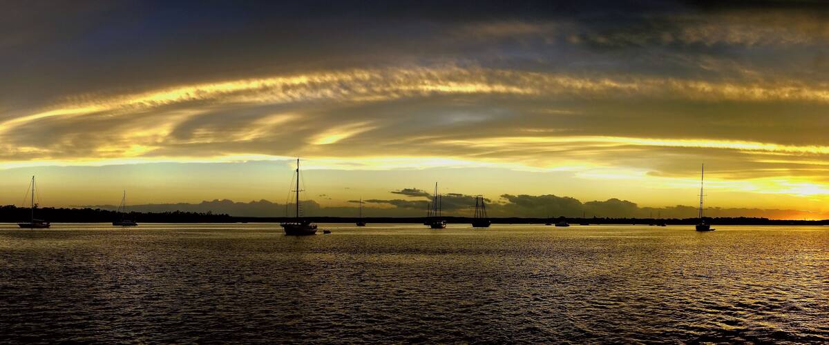 Yellow and gold coloured cirrostratus cloudy coastal nautical Sunset Seascape panorama. Tin Can Bay, Queensland, Australia.