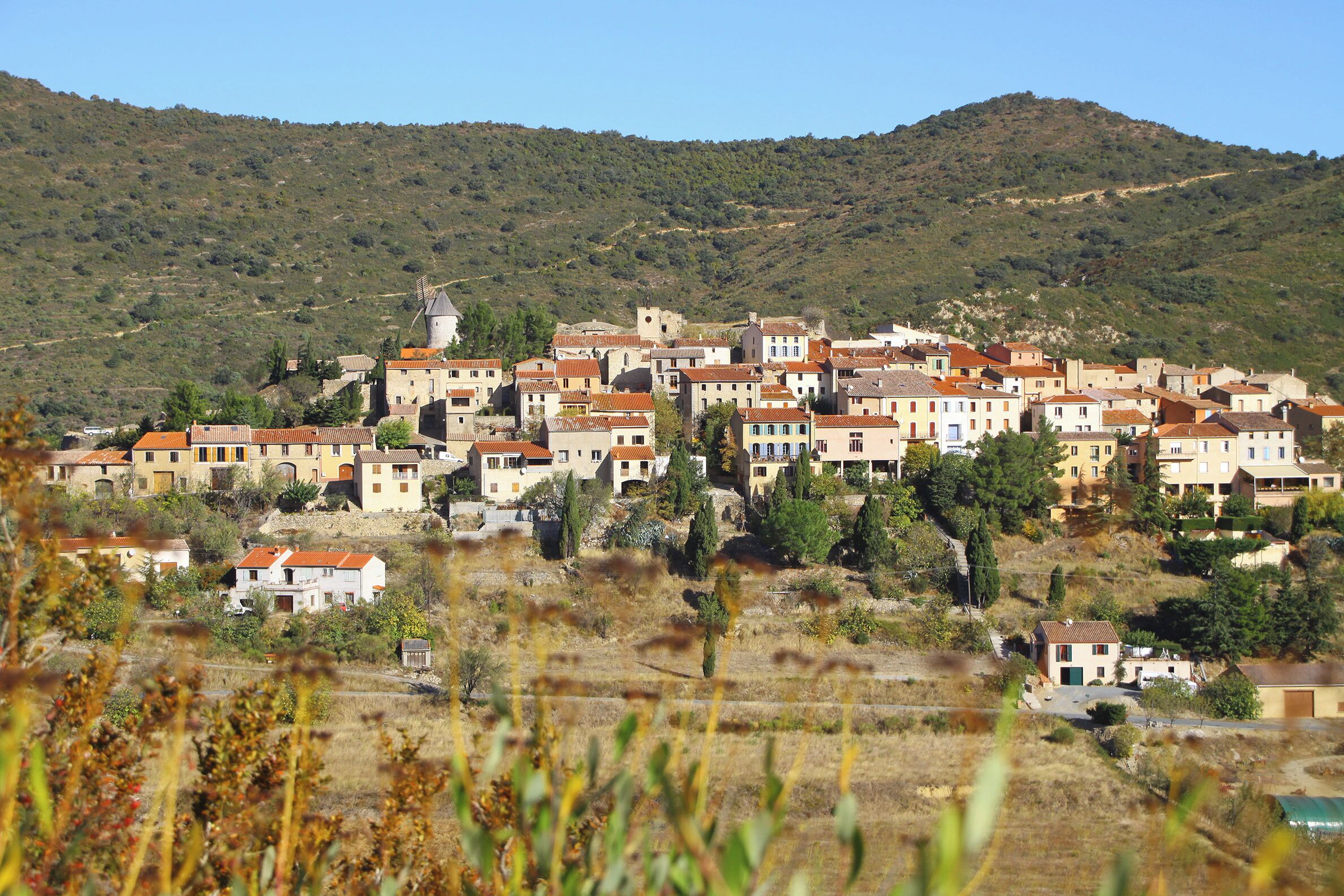 A hillside village with traditional buildings and a windmill.
