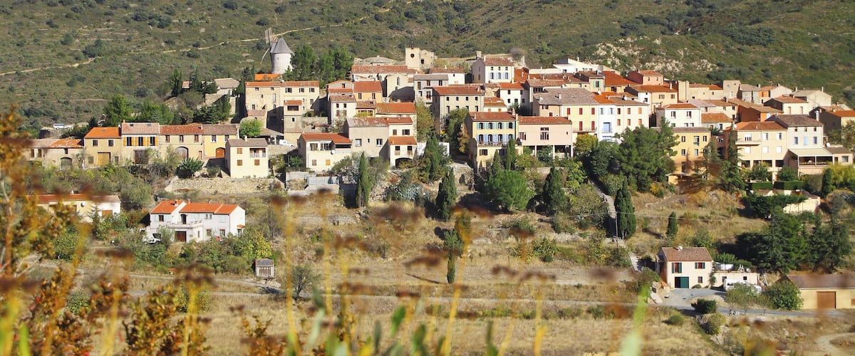 A hillside village with traditional buildings and a windmill.