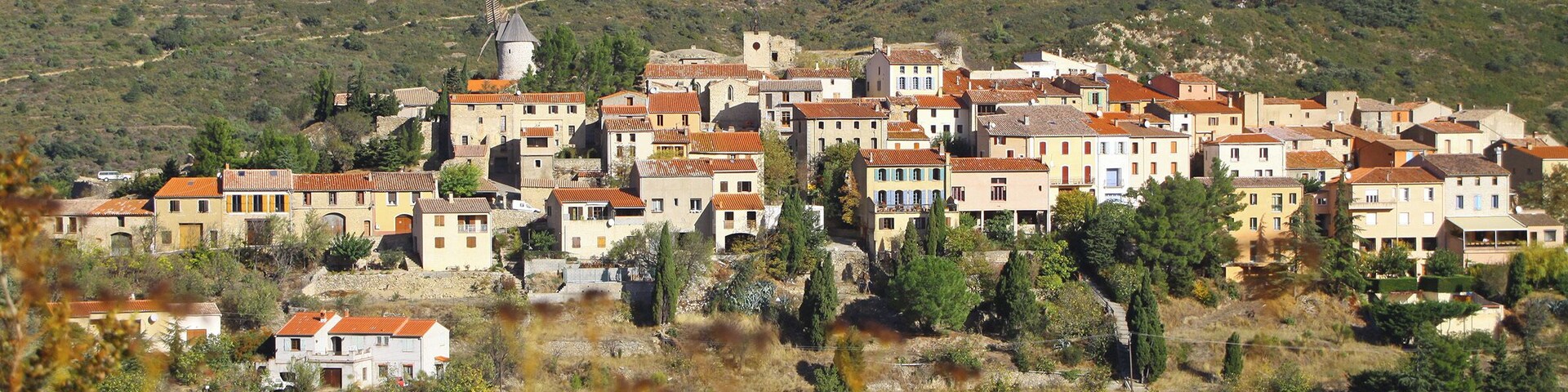 A hillside village with traditional buildings and a windmill.