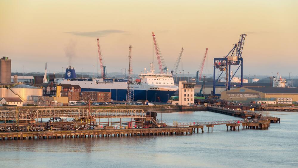A port with a large ship, cranes, and industrial buildings.