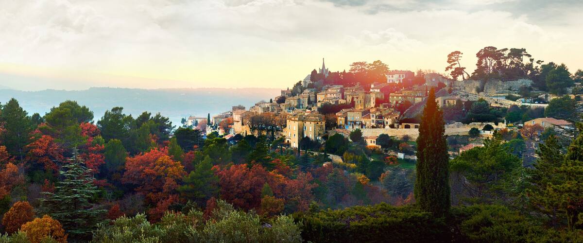 A mountainous town with autumn foliage, historic buildings, and a church.