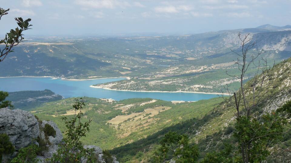 A coastal landscape with a bay, green hills, and rocky outcrops.