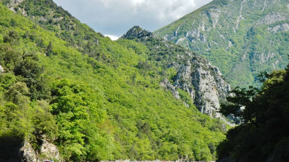 A mountainous landscape with a body of water in the foreground.