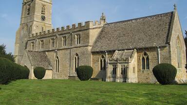 A historic stone church with a tall tower and a large arched entrance.