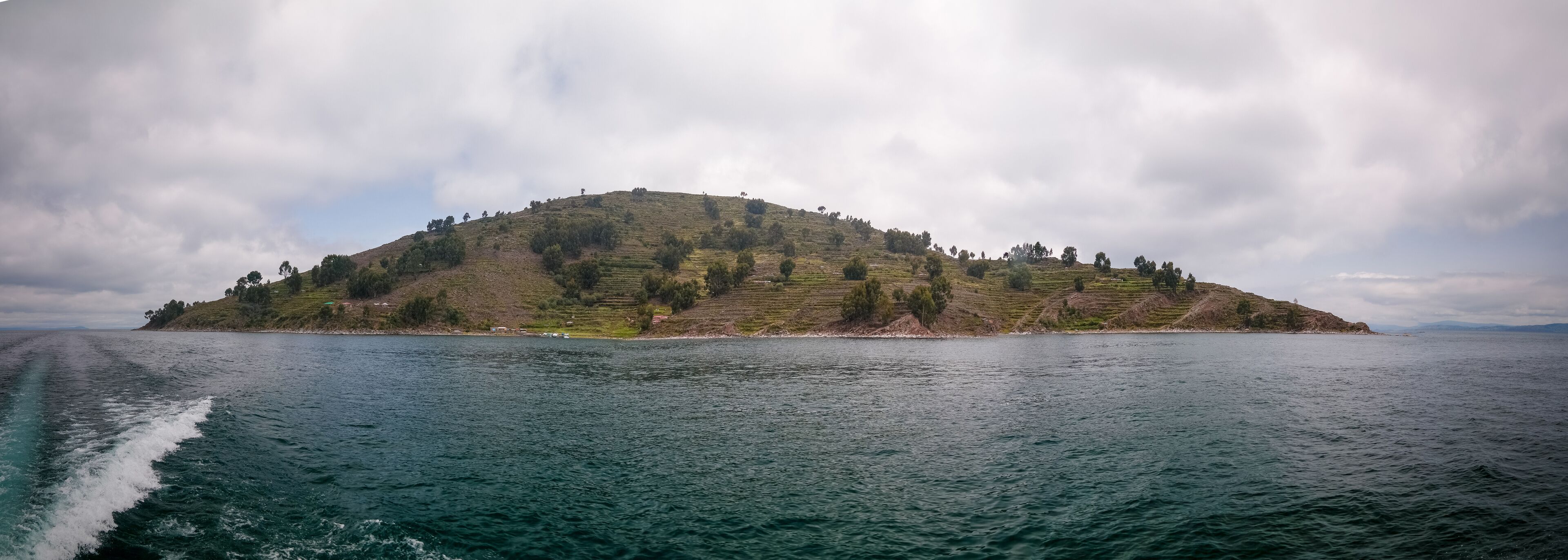 A small island with terraced fields and a body of water in the foreground.