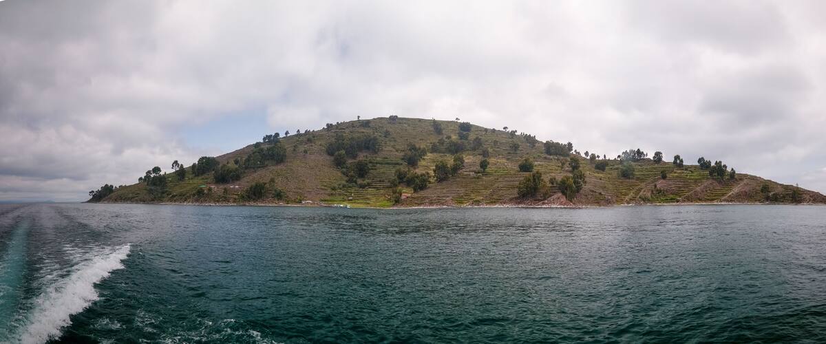 A small island with terraced fields and a body of water in the foreground.