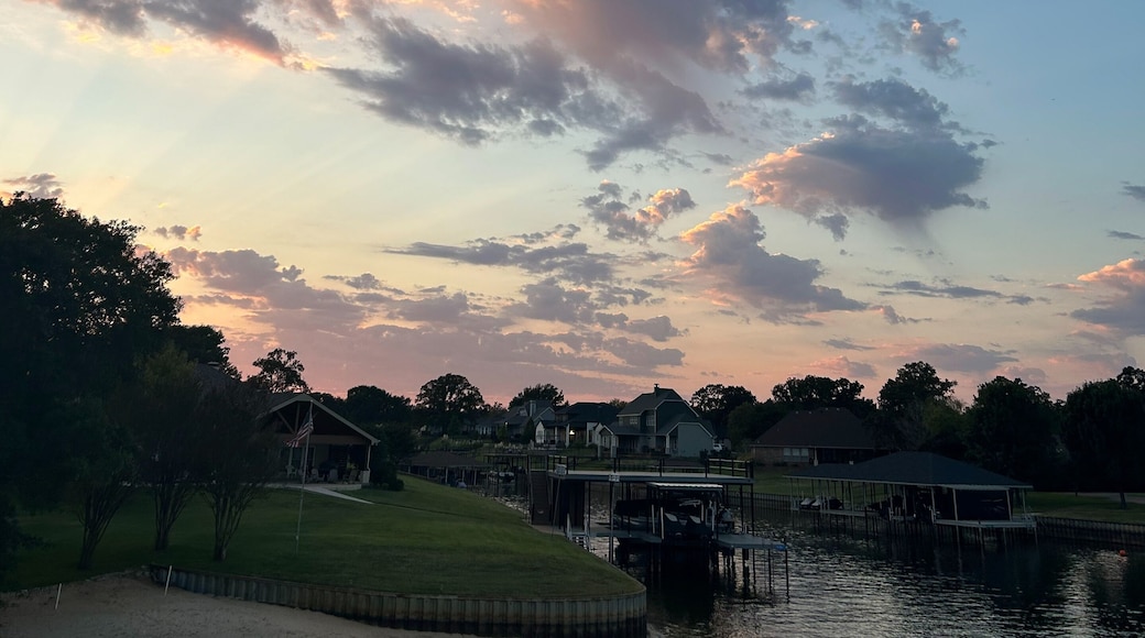 Colorful sunset clouds over Cedar Creek Reservoir waterfront in Texas
