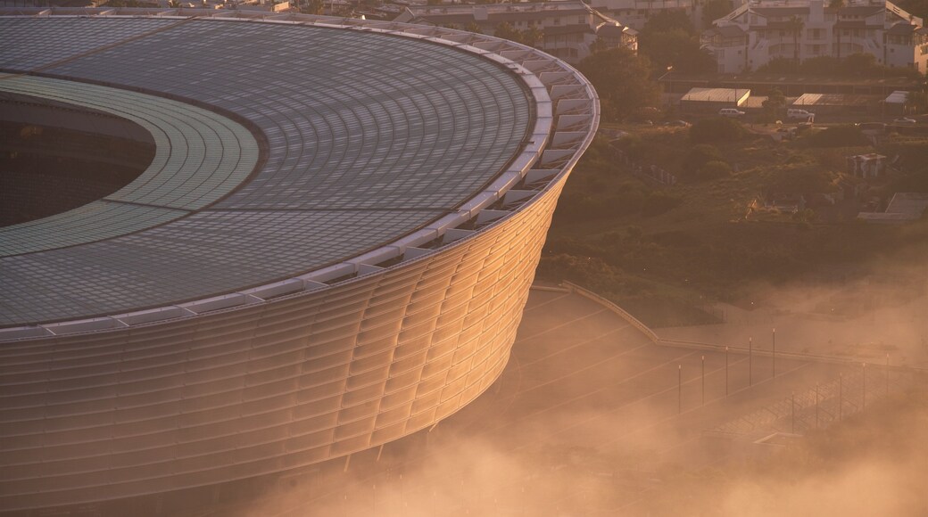 Cape Town Stadium featuring a city and a sunset