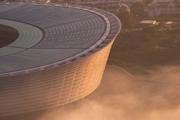Cape Town Stadium das einen Stadt und Sonnenuntergang