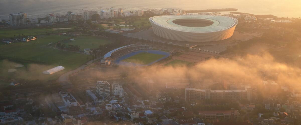 Cape Town Stadium welches beinhaltet Stadt und Sonnenuntergang