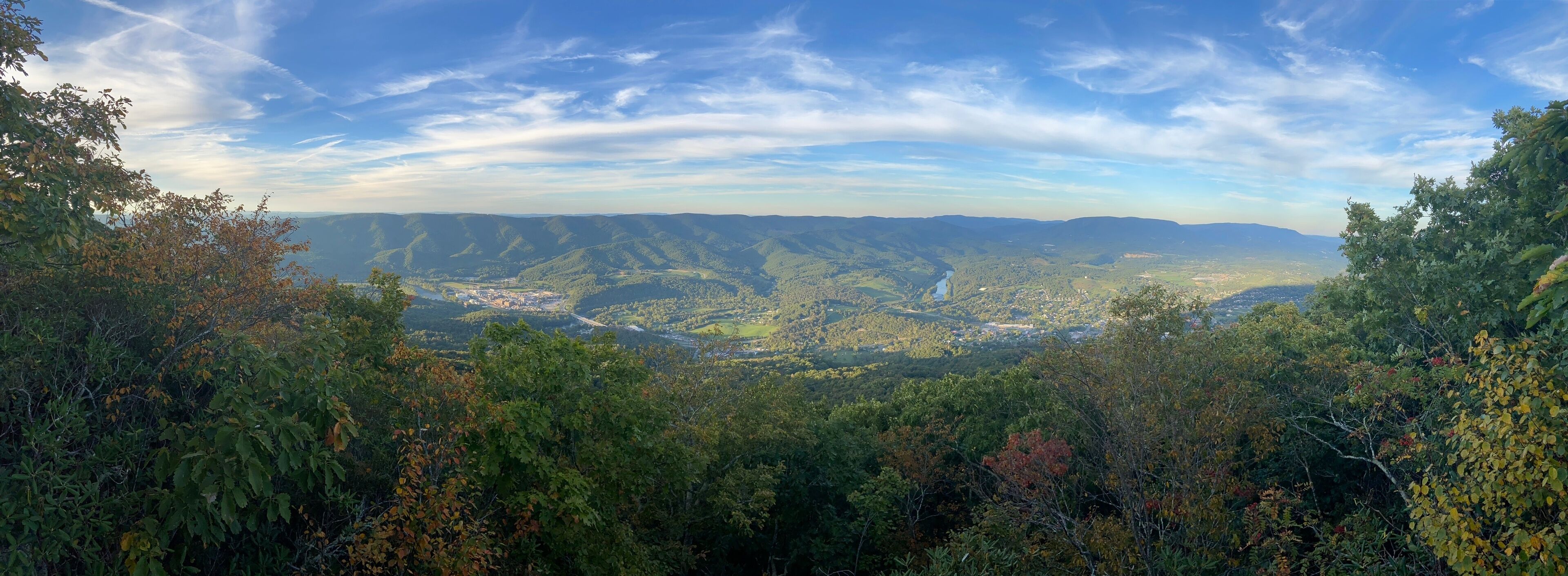 A mountainous landscape with dense forests and a valley below.