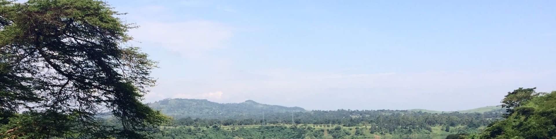A river surrounded by dense greenery and hills in the background.