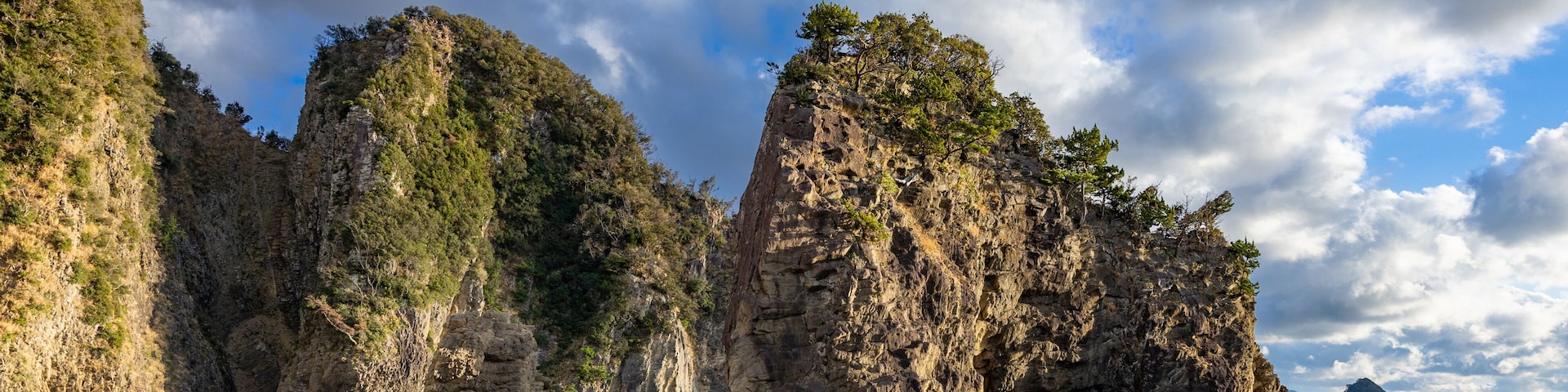 Eine Küstenlandschaft mit markanten Felsformationen und blauem Himmel.
