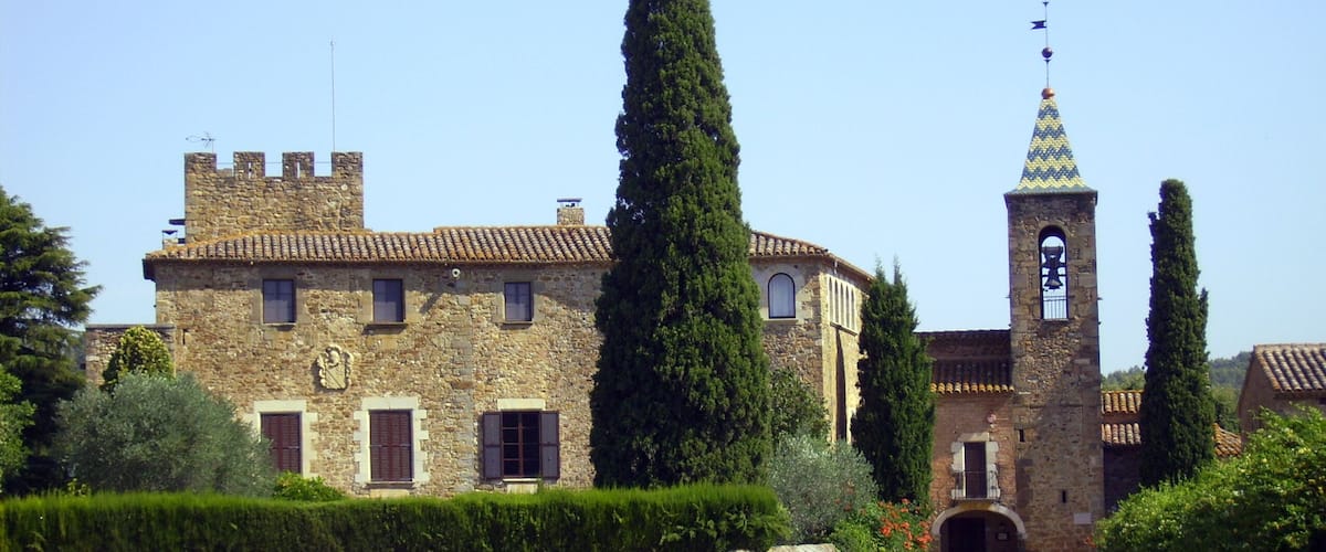 A stone building with a bell tower and a flag on top.