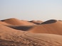 Sand dunes with tracks in the foreground.