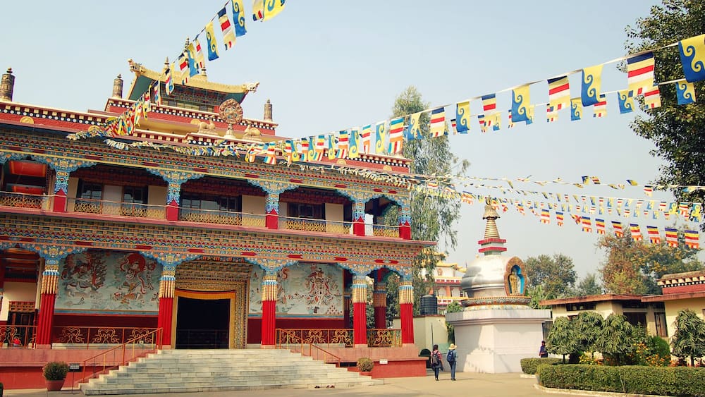 Un temple à plusieurs niveaux, orné de fresques complexes et décoré de drapeaux aux couleurs vives.