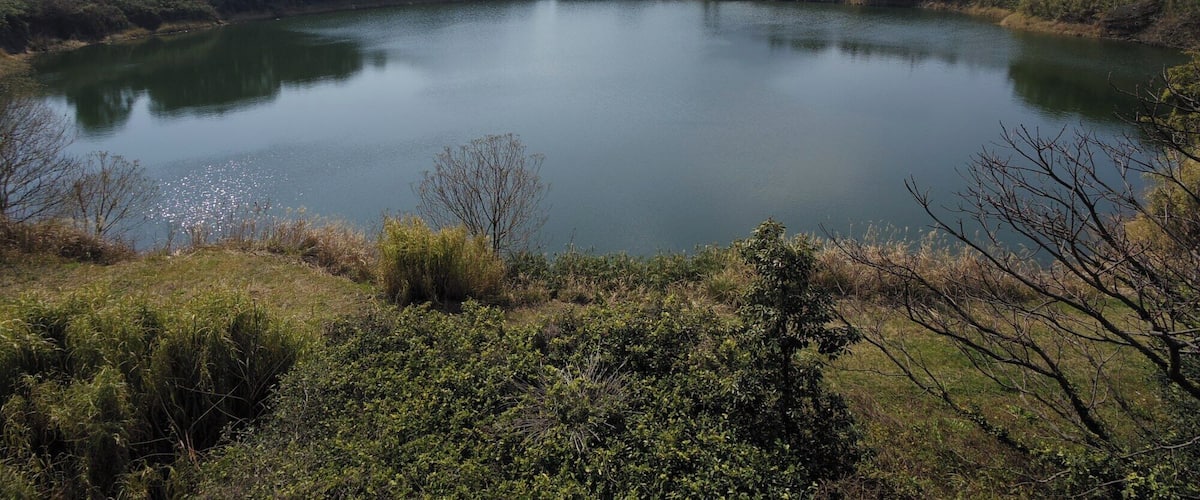 Kagami-ike pond and Mount Kaimon as seen from the Northeast. This pond is a volcanic crater of the Ikeda Volcano.