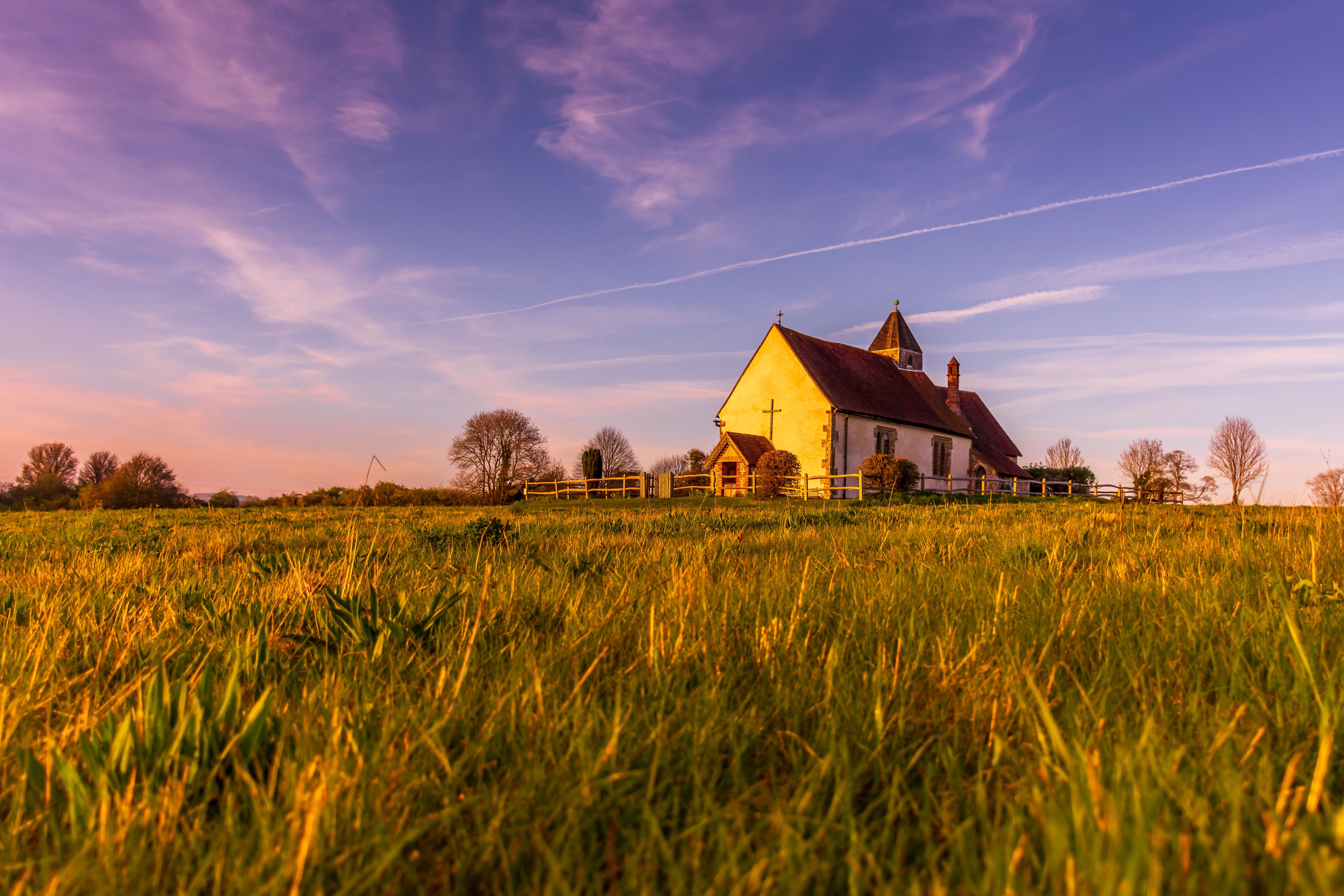 A church on a hill with a field in the foreground.