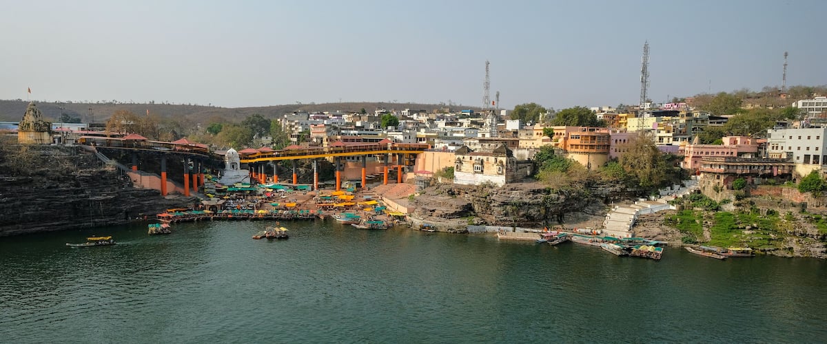 A river with boats, a bridge, and a temple.