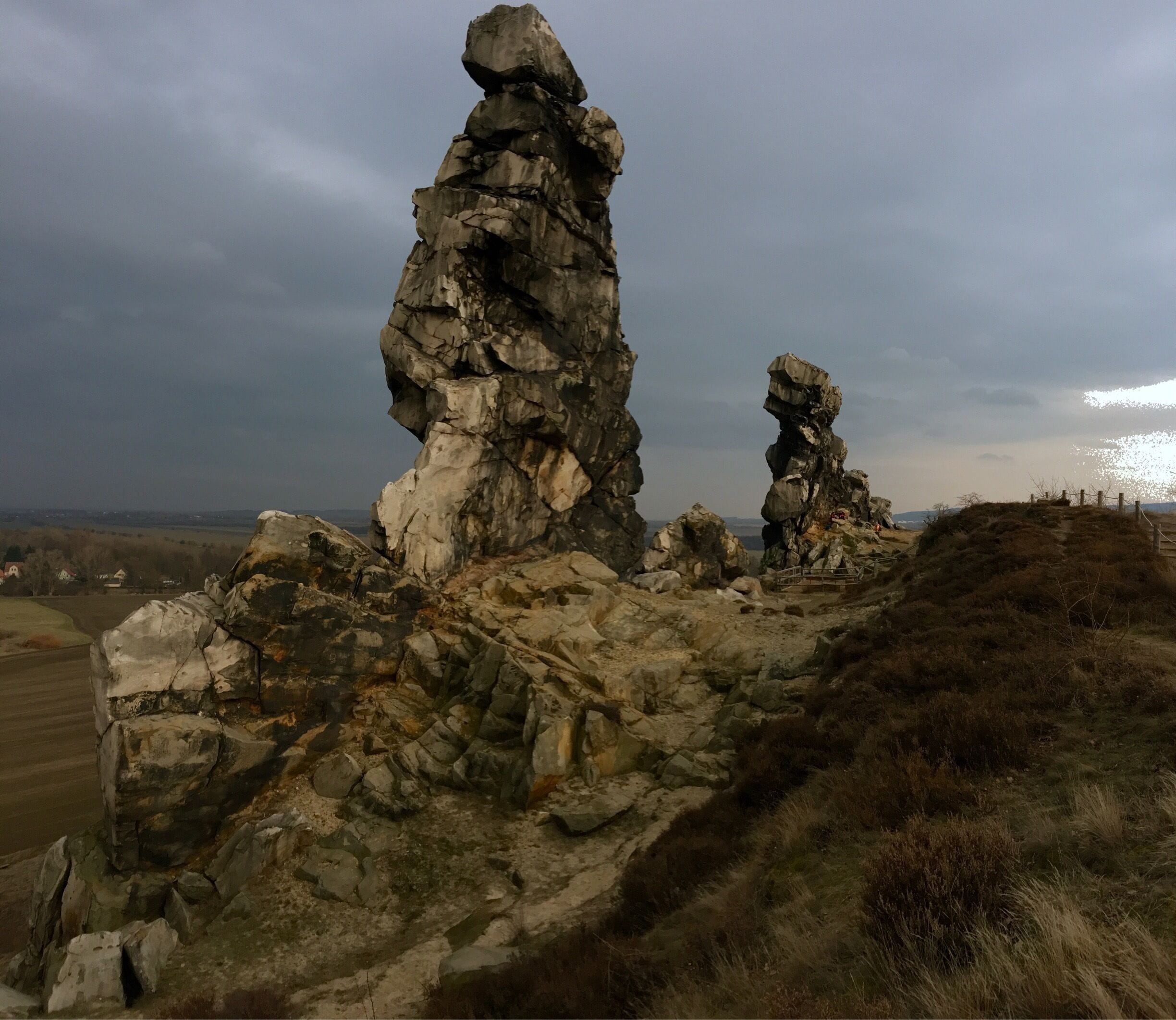 A rocky landscape with prominent rock formations and a distant view of a body of water.
