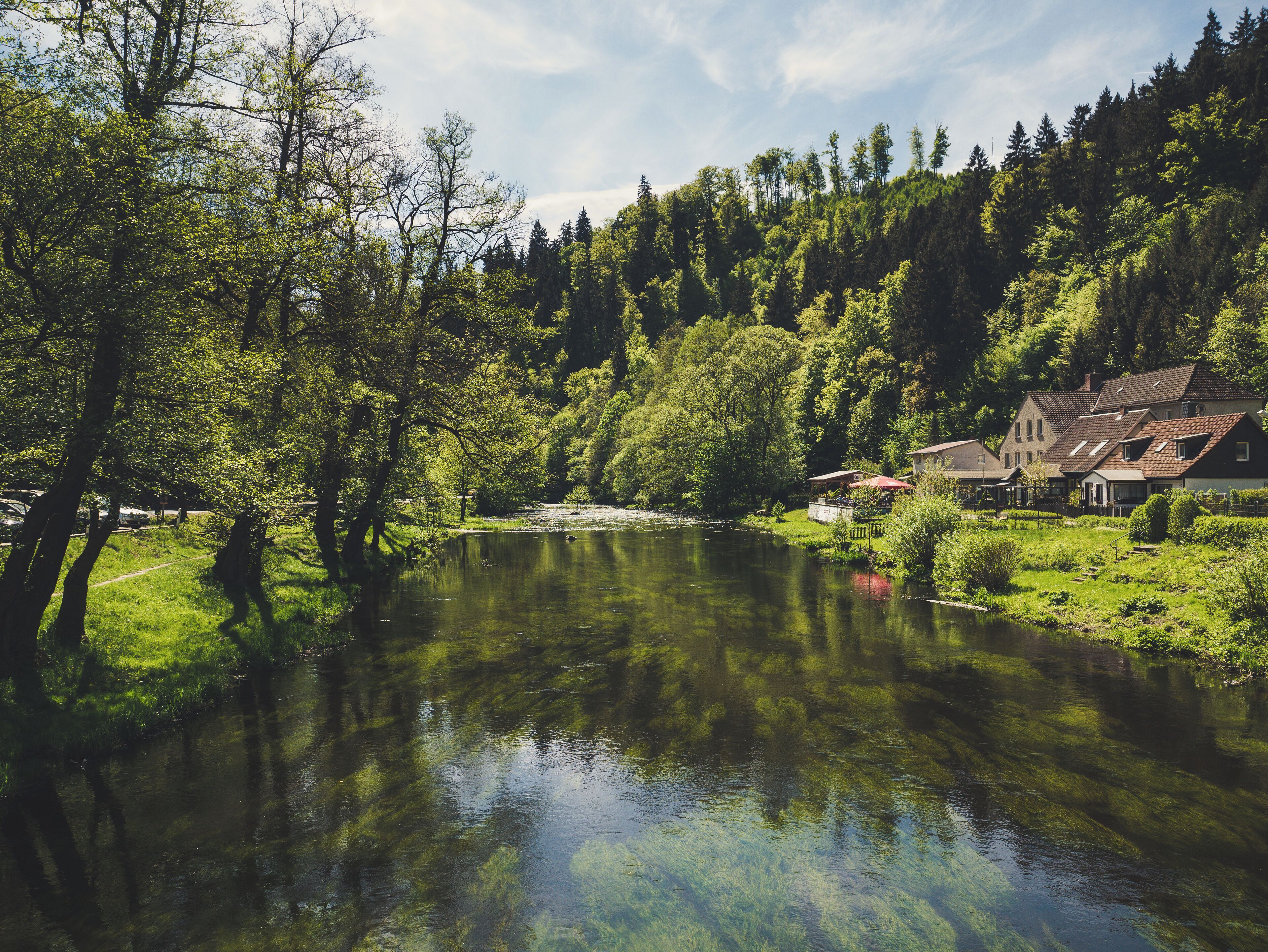 A calm river surrounded by lush greenery and traditional houses.