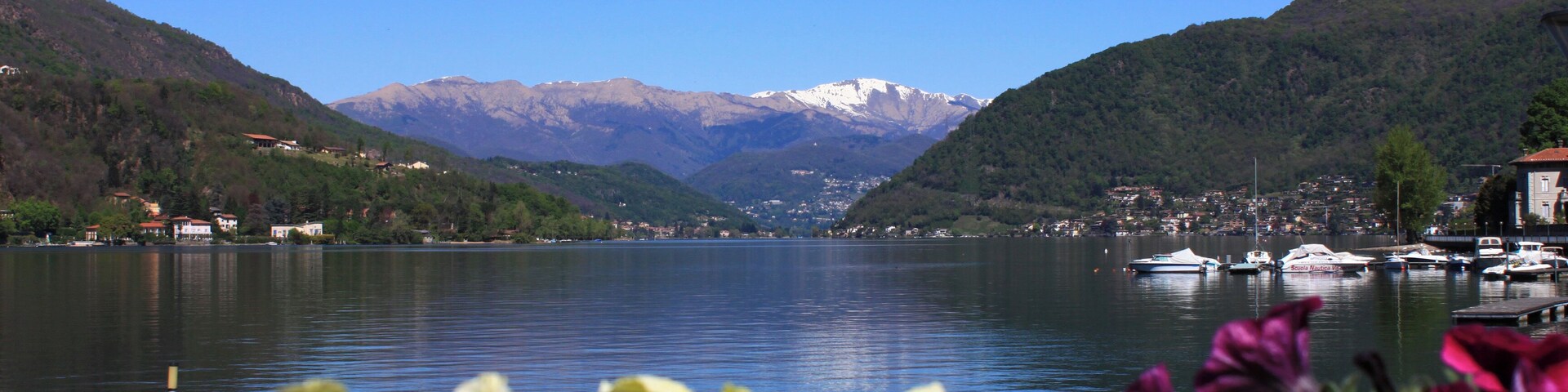 Frühling am Lago di Lugano fotografiert von der Uferpromenade des Seeortes Porto Ceresio.Porto Ceresio ist eine Gemeinde mit ca. 3000 Einwohnern in der Provinz Varese (Lombardei) direkt gegenüber dem Schweizer Tessin.