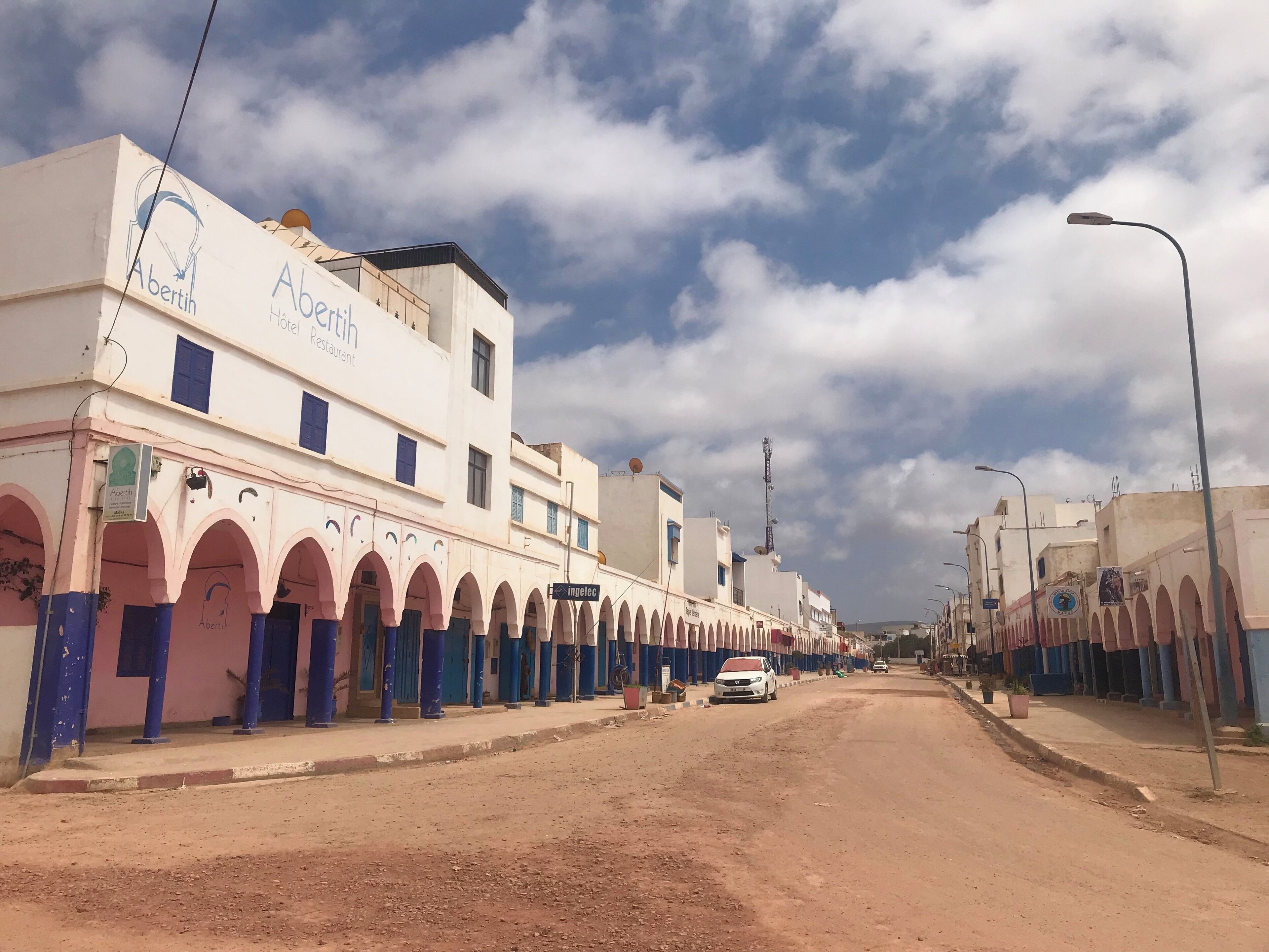 A street lined with buildings featuring arches and signage for 'Abertin Hotel Restaurant'.