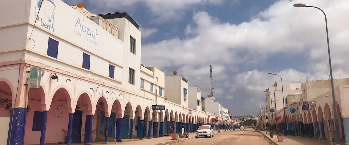 A street lined with buildings featuring arches and signage for 'Abertin Hotel Restaurant'.