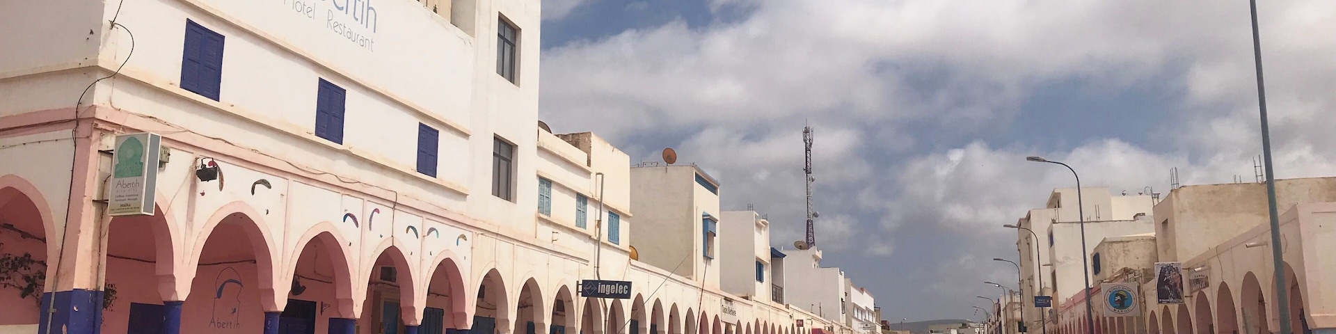 A street lined with buildings featuring arches and signage for 'Abertin Hotel Restaurant'.