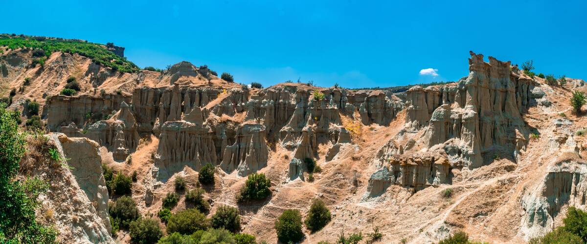 A rugged, eroded landscape with steep cliffs and sparse vegetation.