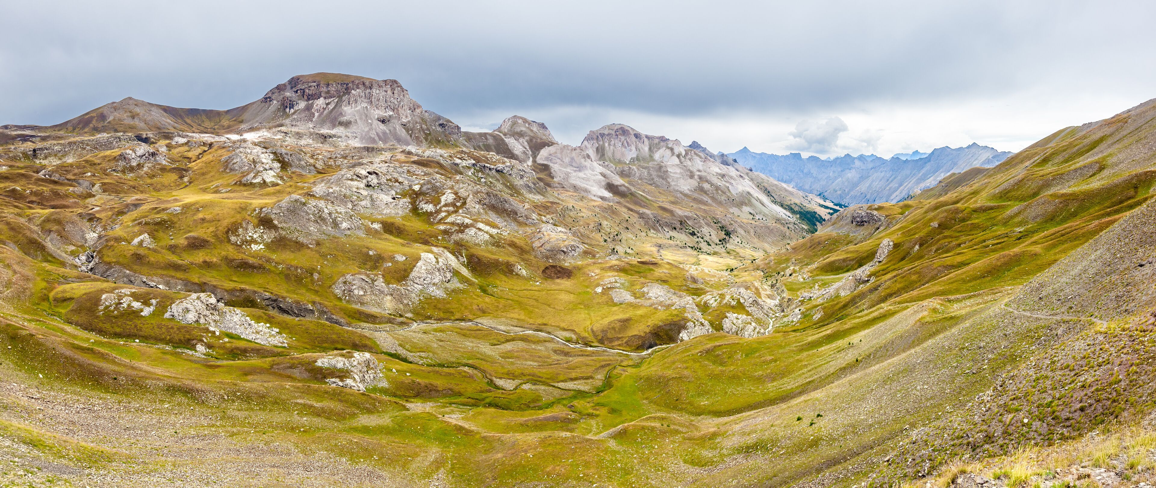 A rugged mountainous landscape with a valley and rocky terrain.