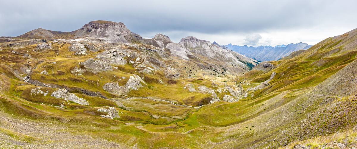 A rugged mountainous landscape with a valley and rocky terrain.