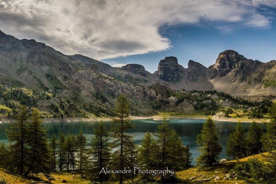Un paisaje montañoso con un lago y un bosque denso.